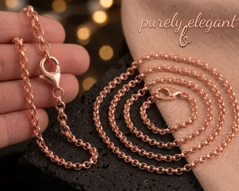 Rose gold chain necklace on a textured surface with 'purely elegant' branding.