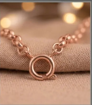 Rose gold bracelet on a beige fabric background