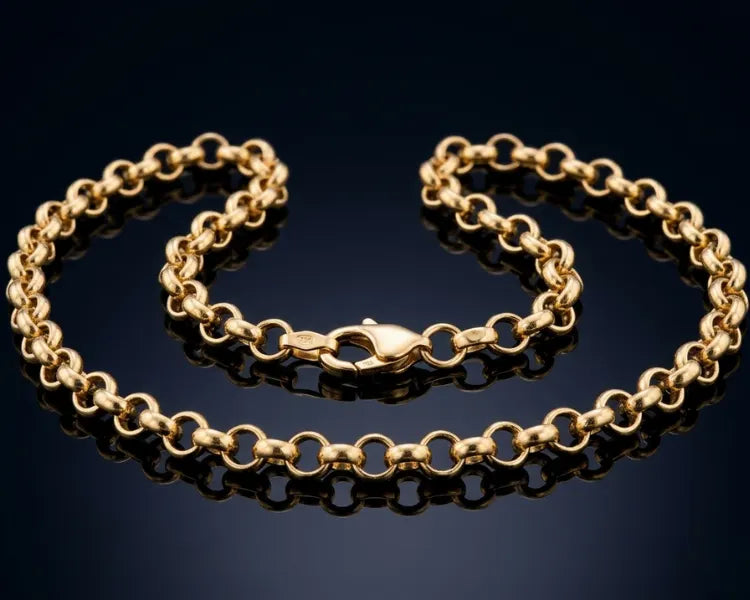 Gold chain bracelet on a reflective black surface