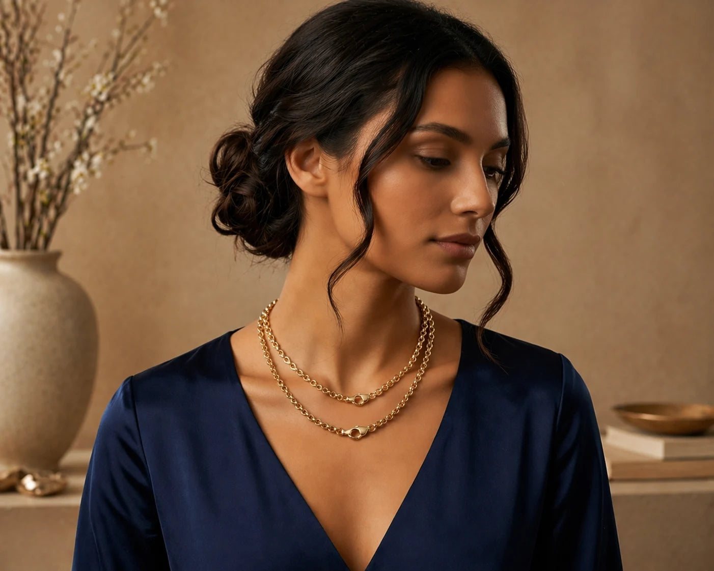 Woman wearing a gold necklace with a neutral background