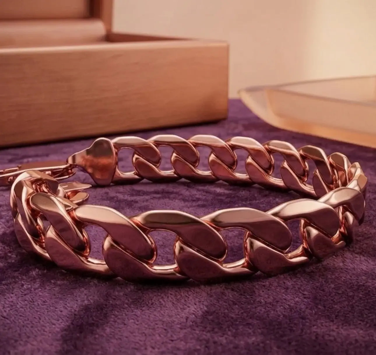 Rose gold chain bracelet on a purple fabric background