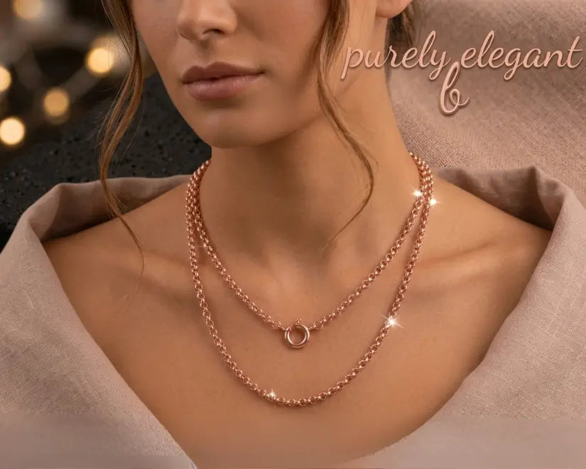 Rose gold chain necklace on a textured surface with 'purely elegant' branding.