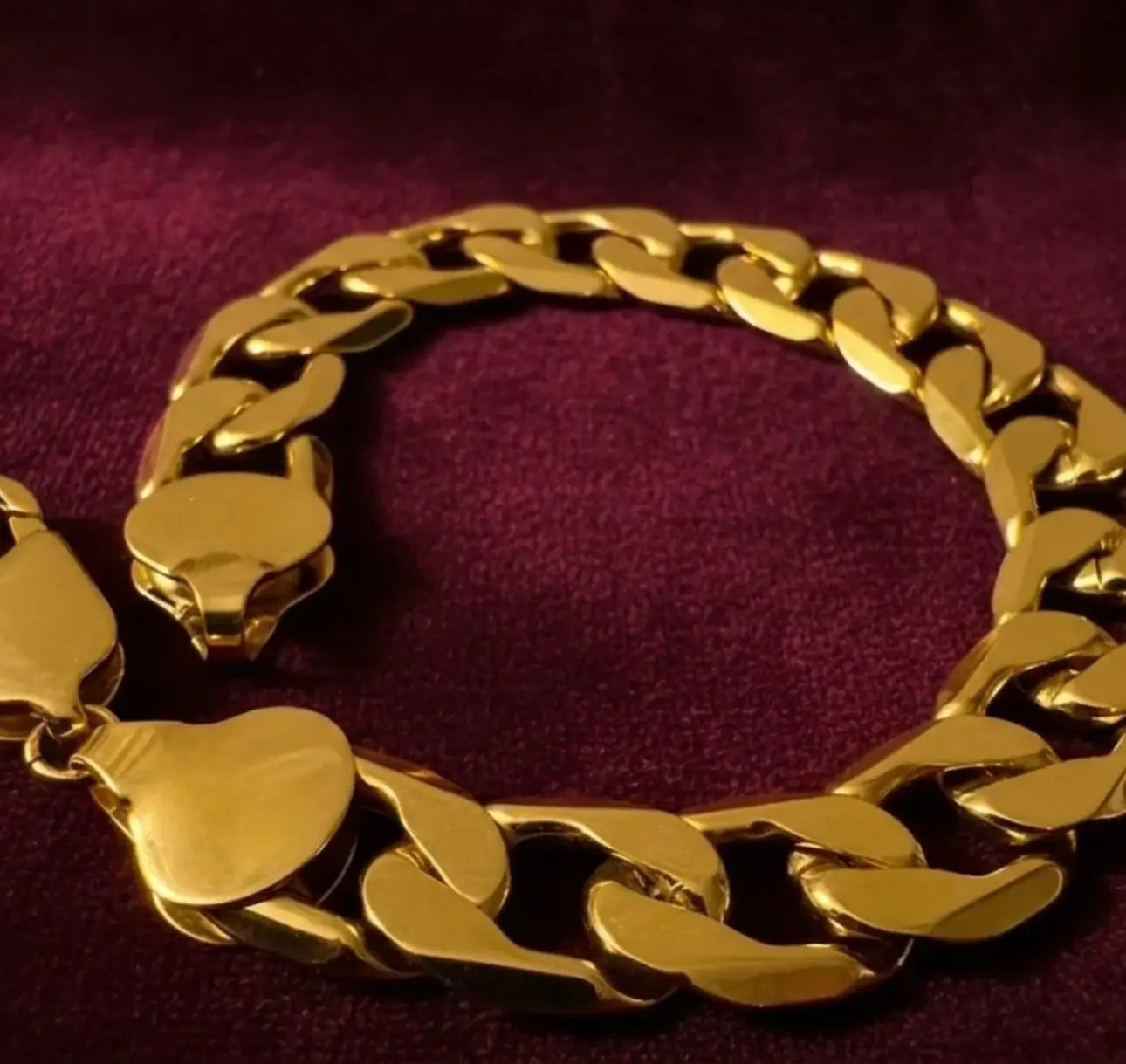Gold chain bracelet on a purple fabric background