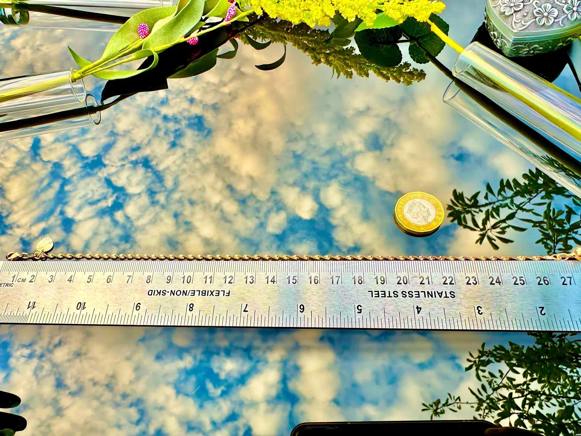 Glass surface with floral reflections and a ruler for scale