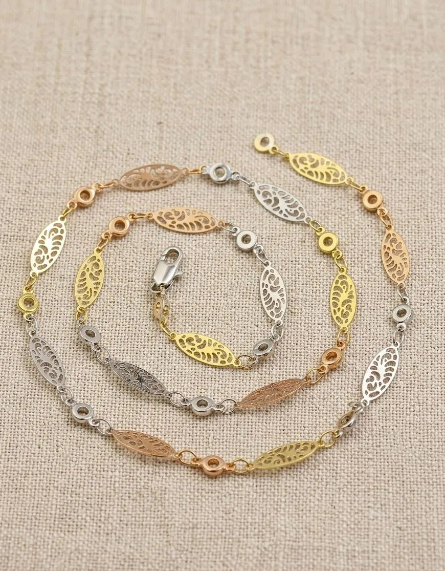 Three gold and silver bracelets on a beige fabric background