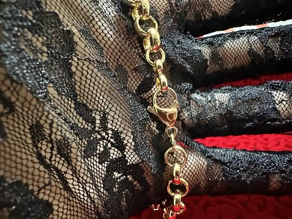 Gold chain with a clasp on a black lace fabric background