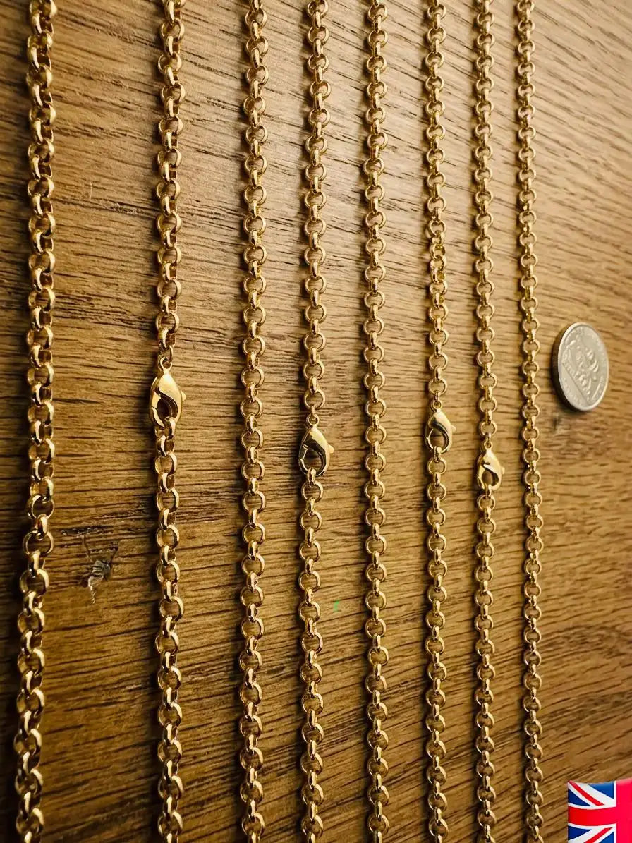 Gold chains of different lengths on a wooden surface with a coin for scale.