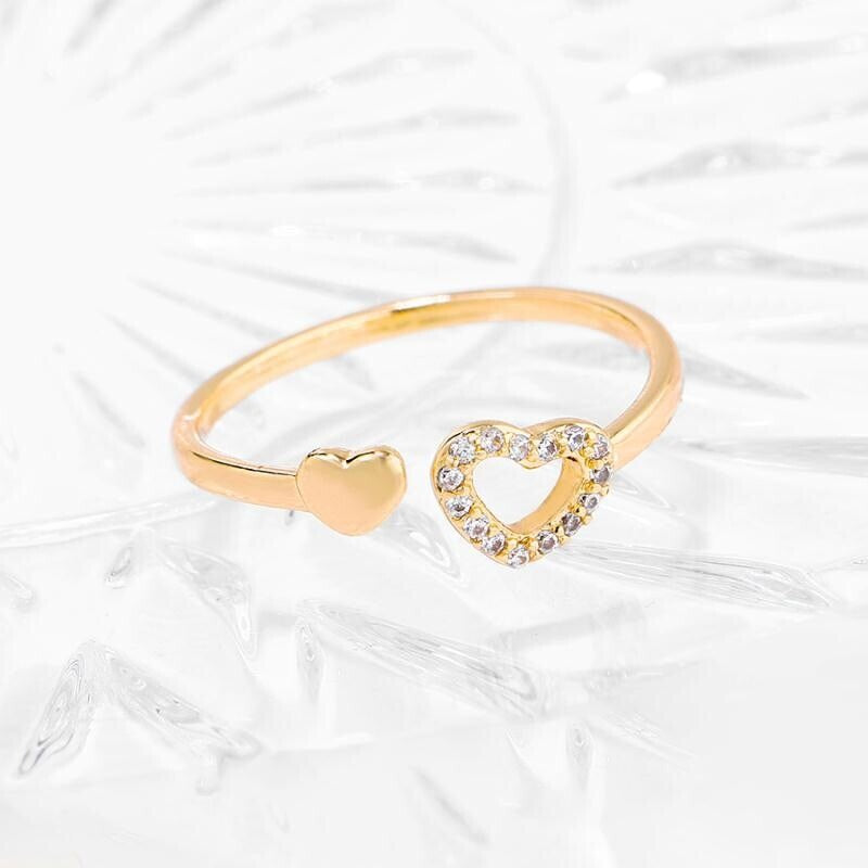 Gold heart-shaped ring with a smaller heart-shaped ring on a white background