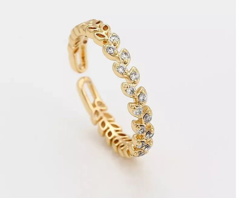 Gold ring with diamond accents on a light gray background