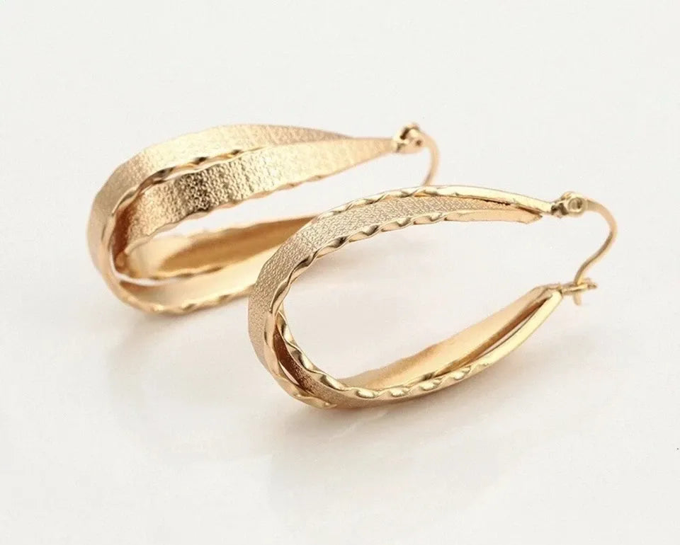 Gold hoop earrings on a light background