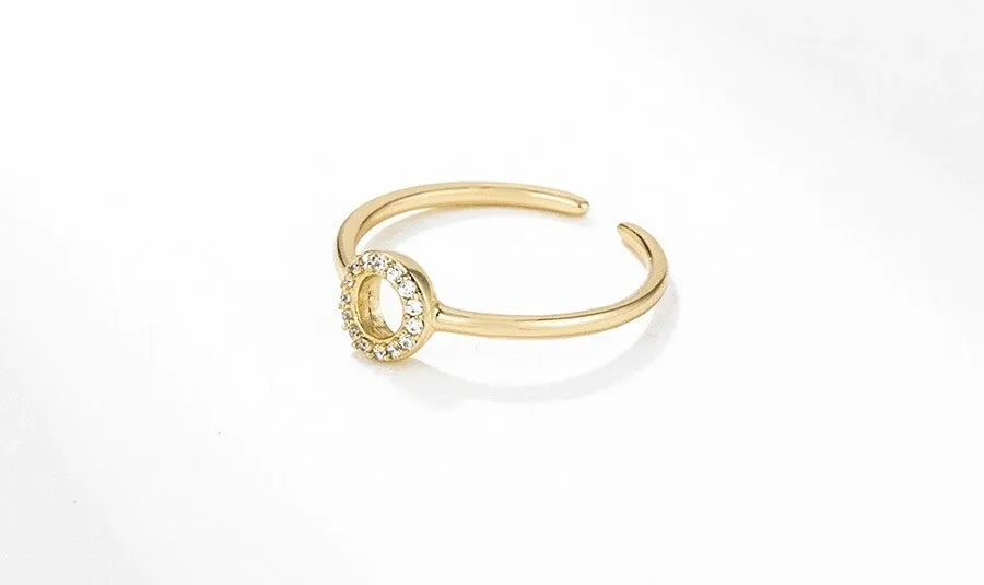 Gold ring with a small circular gemstone on a white background