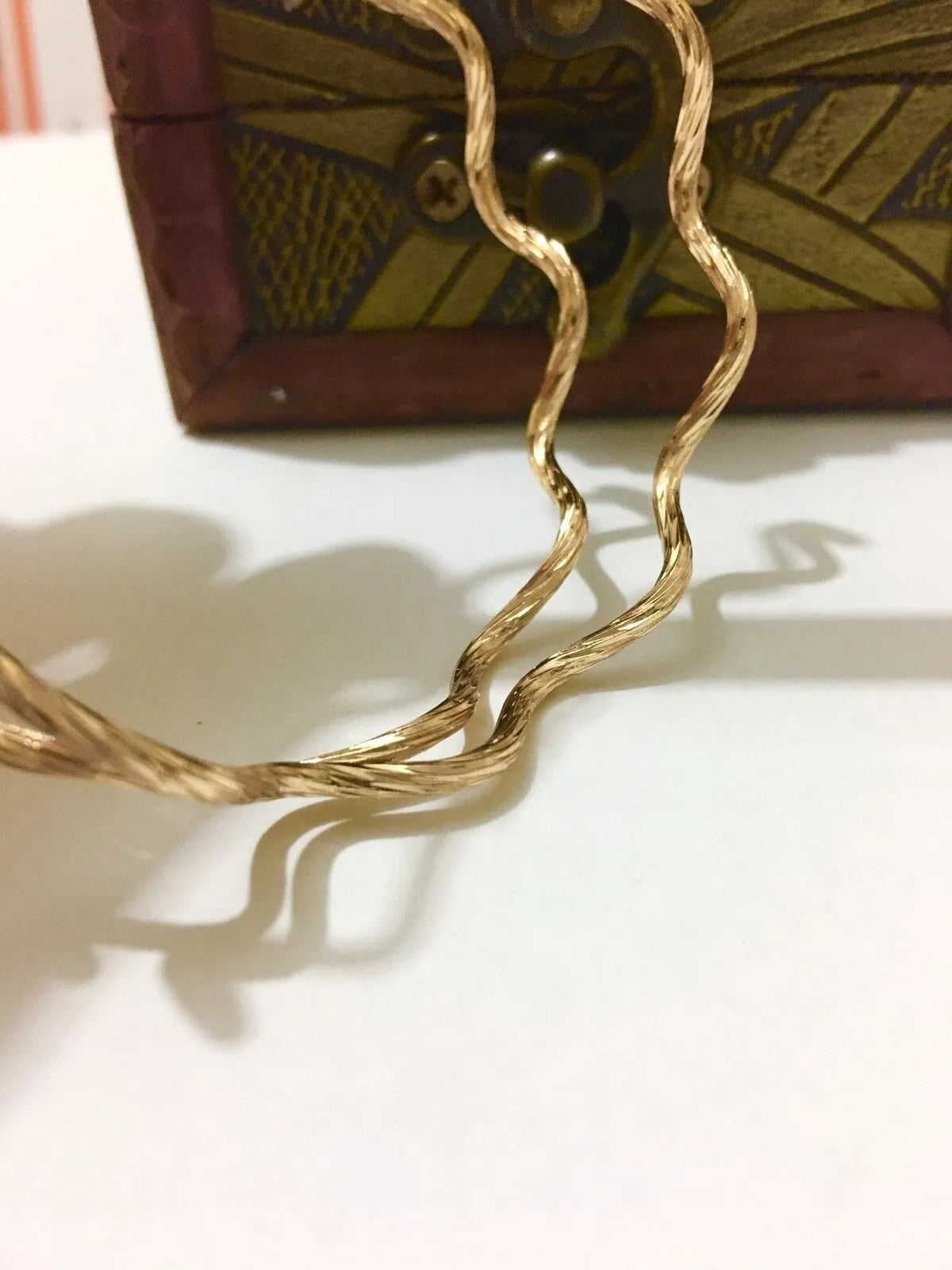 Gold braided cable on a white surface with a decorative box in the background