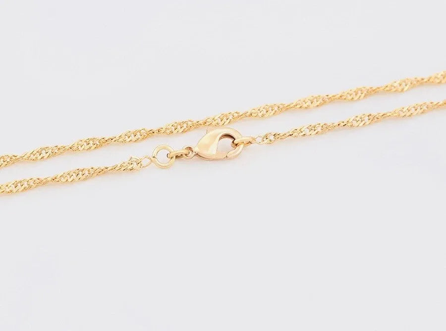 Gold chain Anklets on a light gray background