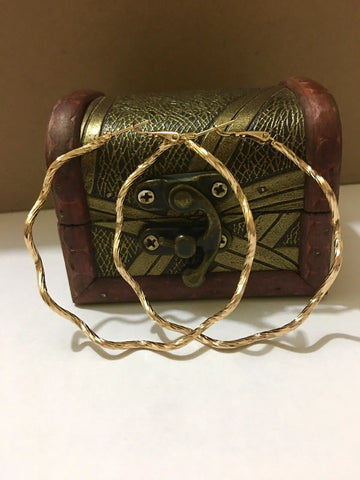 Wooden spool with gold thread on a white surface