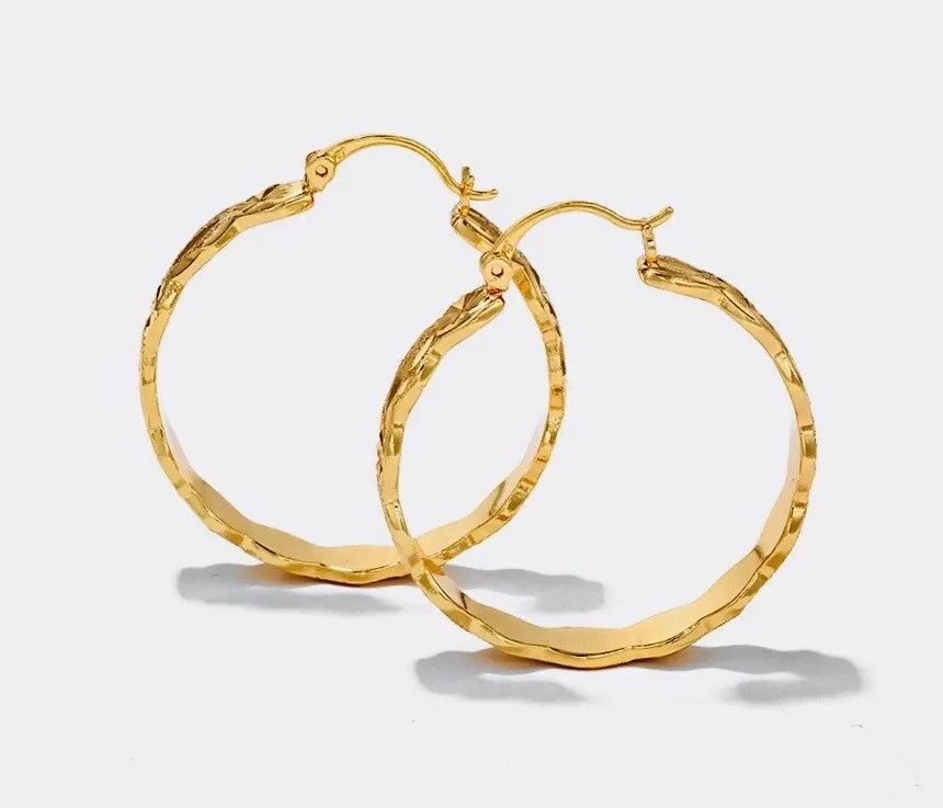 Gold hoop earrings on a light gray background