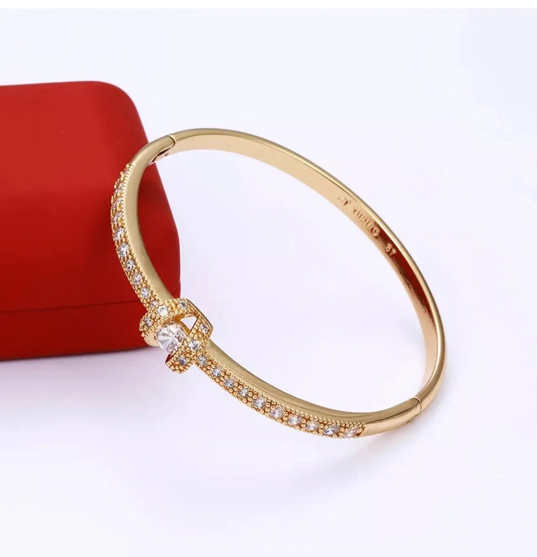 Gold bracelet with diamond accents on a white background