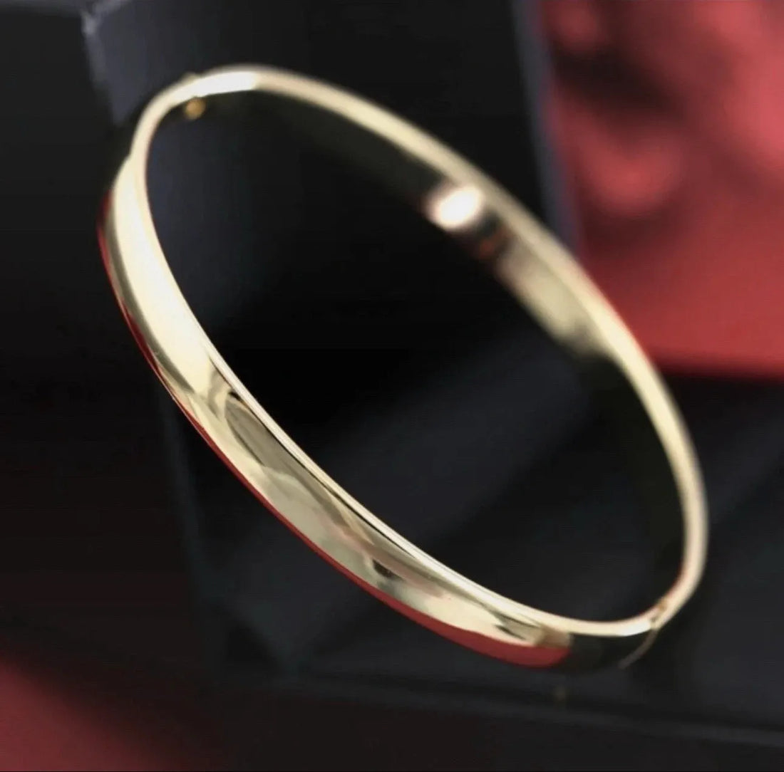 Gold bracelet on a dark fabric background