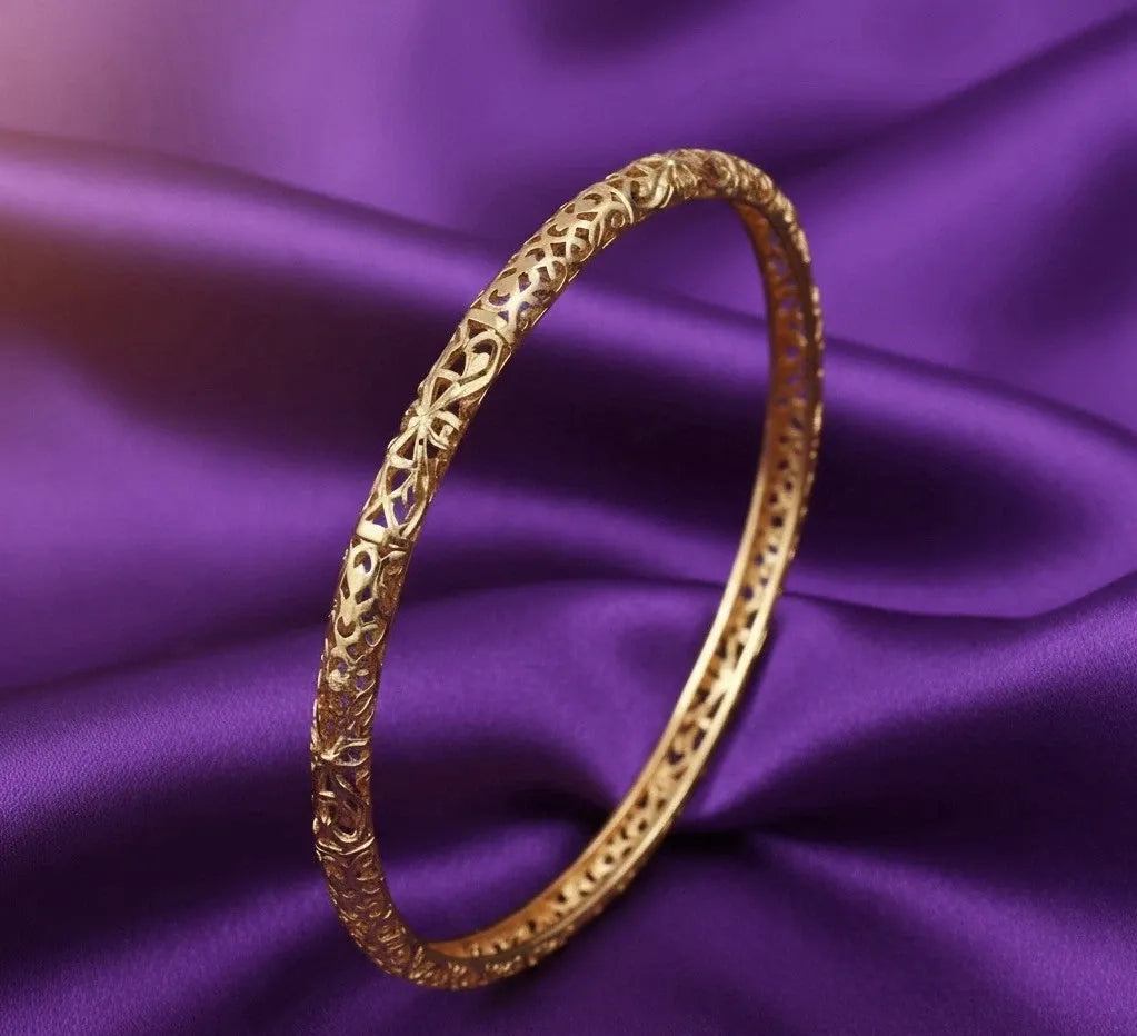 Gold bracelet on a purple fabric background