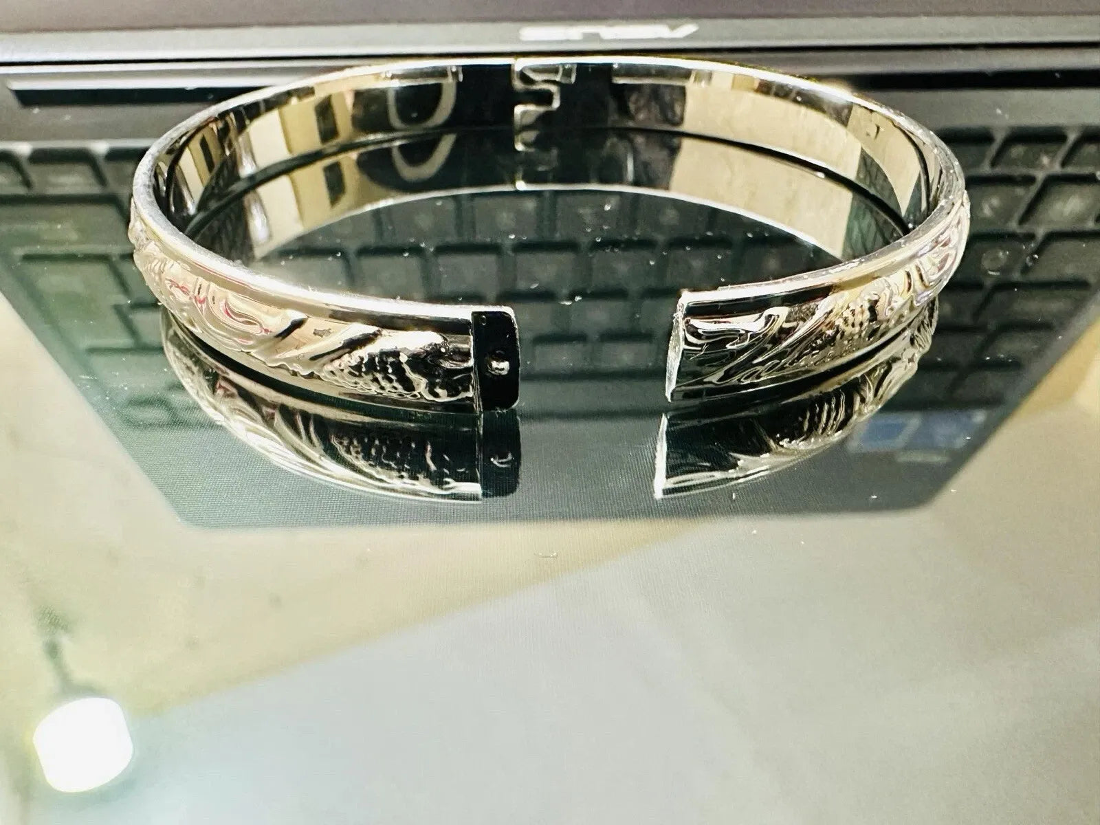Silver bracelet on a reflective surface
