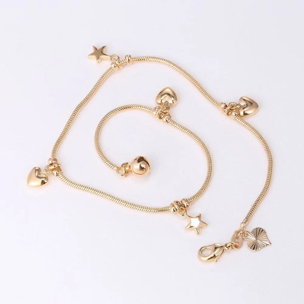 Gold bracelet with star and heart charms on a white background
