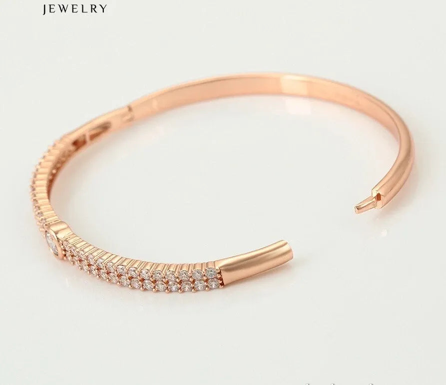 Rose gold bracelet with diamond accents on a light background