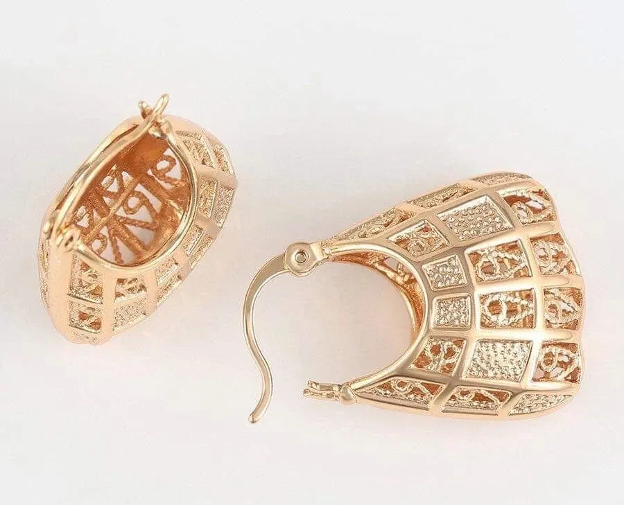 Gold hoop earrings with intricate designs on a white background
