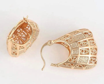 Gold hoop earrings with intricate designs on a white background