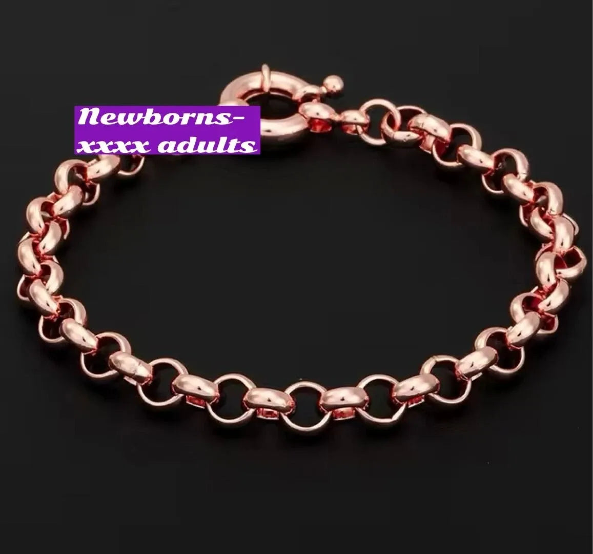 Rose gold bracelet on a black background with a purple label.