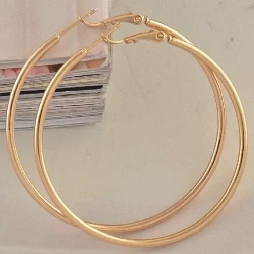 Gold hoop earrings on a light gray background