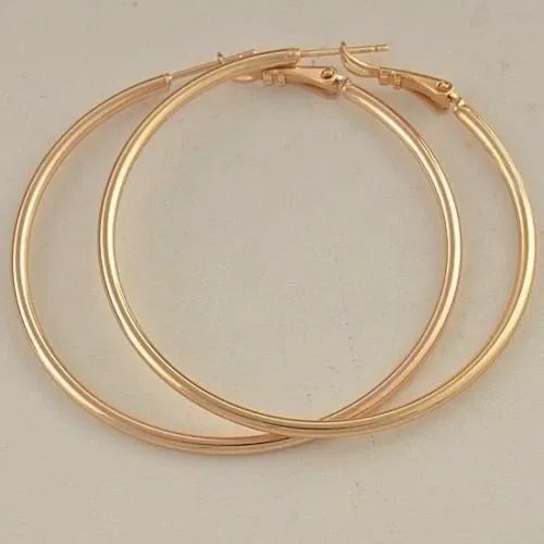 Gold hoop earrings on a light gray background