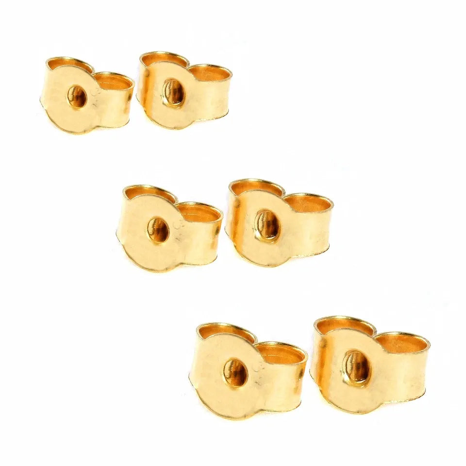 Set of gold ear cuff pieces on a white background