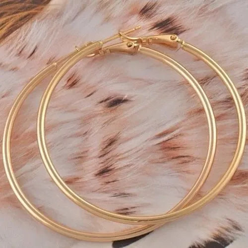 Gold hoop earrings on a fur surface