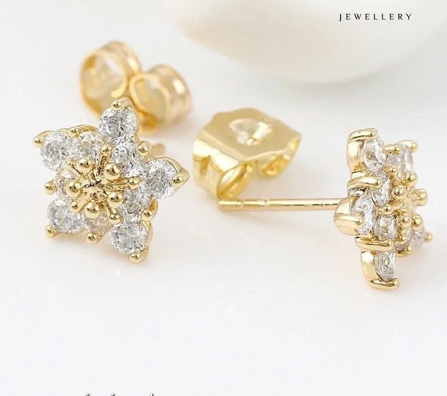 Gold earrings with diamond-like stones on a white background