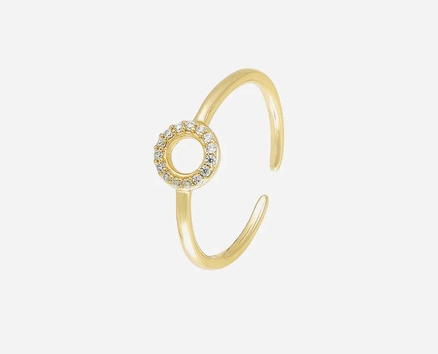 Gold ring with a circular design and small stones on a white background