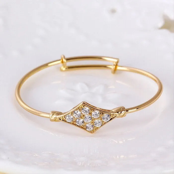 Gold bracelet with diamond accents on a white background