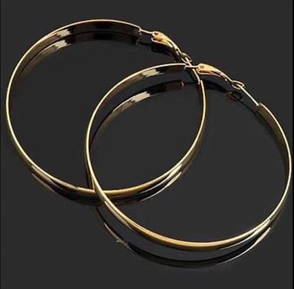 Gold hoop earrings on a black background