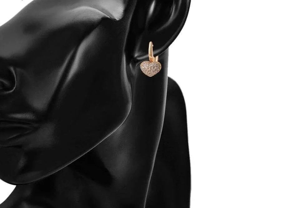 Heart-shaped earrings on a black mannequin with a white background