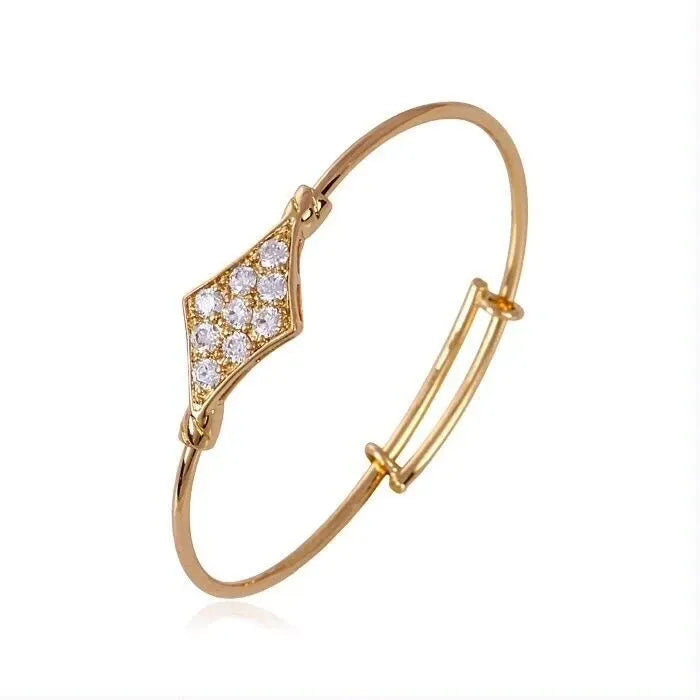 Gold bracelet with diamond-like stones on a white background
