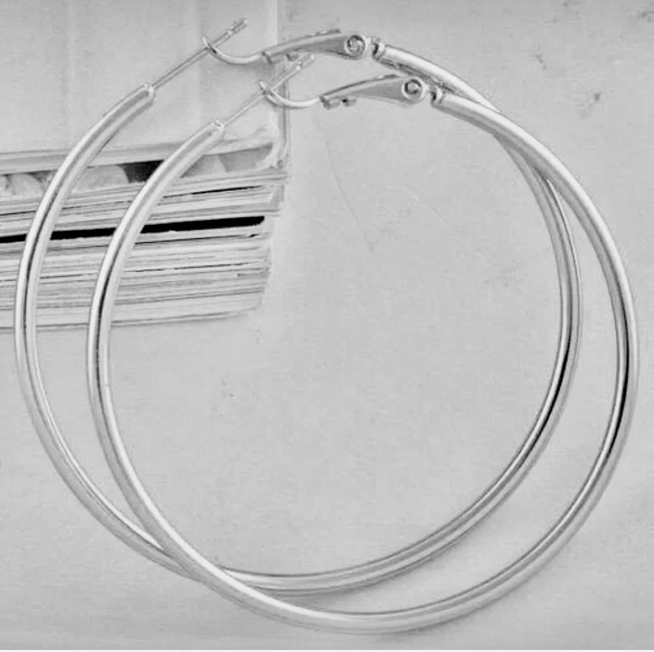 Pair of silver hoop earrings on a light gray background