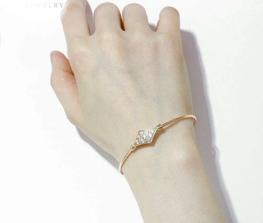  gold bracelet with clear stones on a wrist against a white background