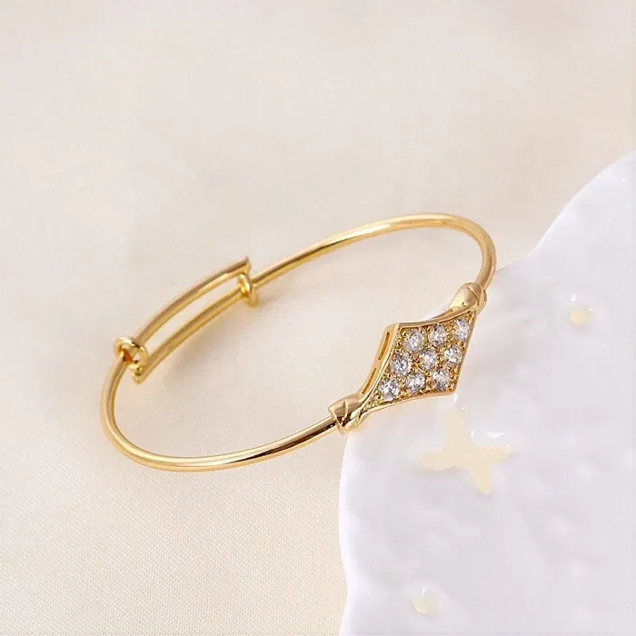 Gold bracelet with diamond accents on a light beige background
