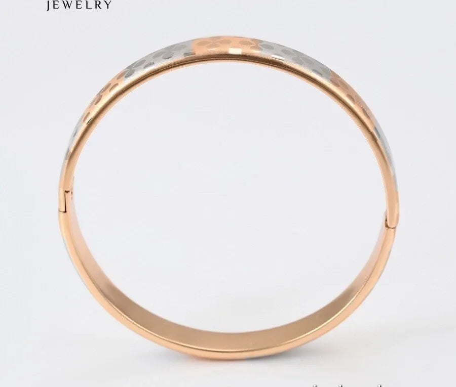 Two-toned gold and silver bracelet on a light gray background
