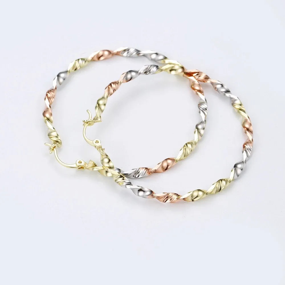 Two gold bracelets with a twisted design on a white background