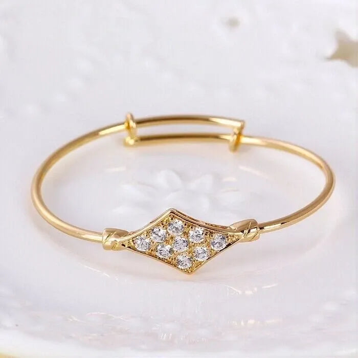  gold bracelet with clear stones on a wrist against a white background