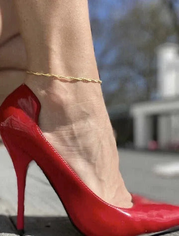 Red high-heeled Anklets shoes worn on a blurred outdoor background
