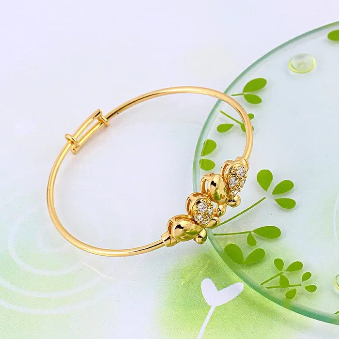 Gold bracelet with floral design on a white background