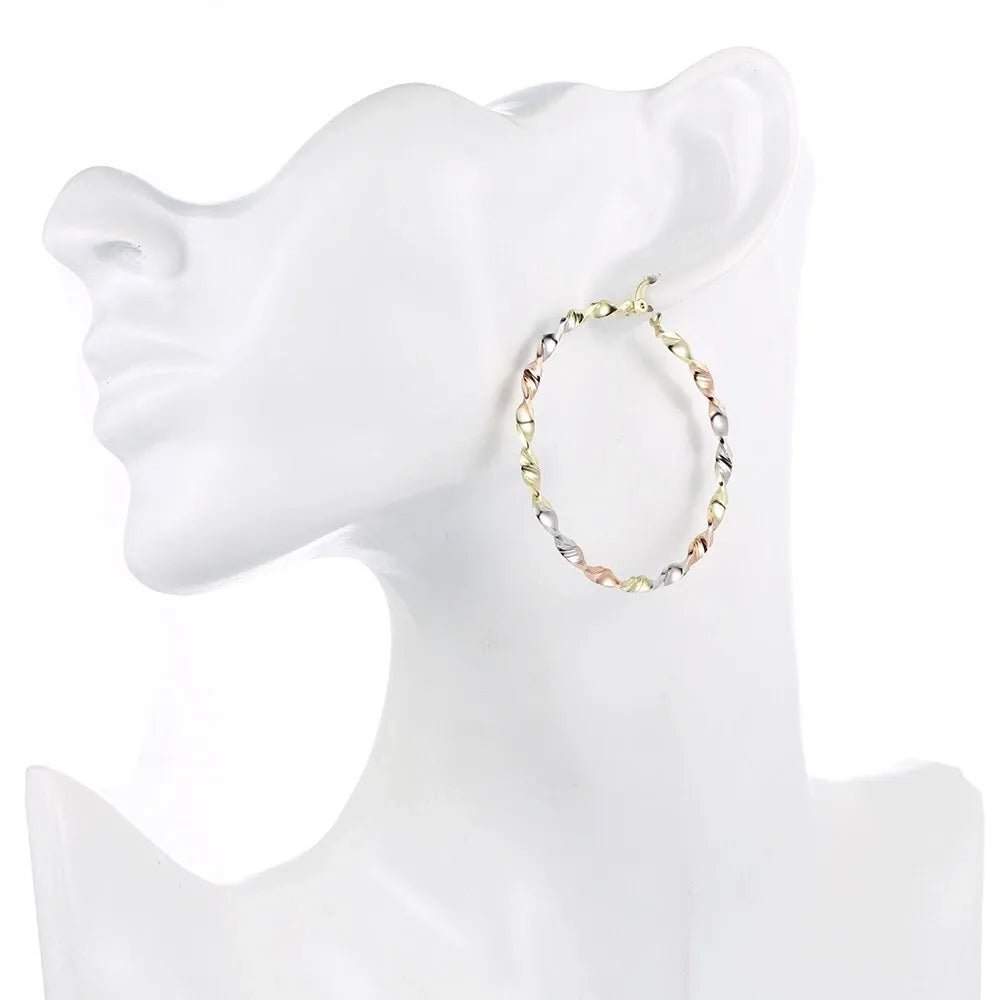 Gold hoop earring on a white mannequin bust
