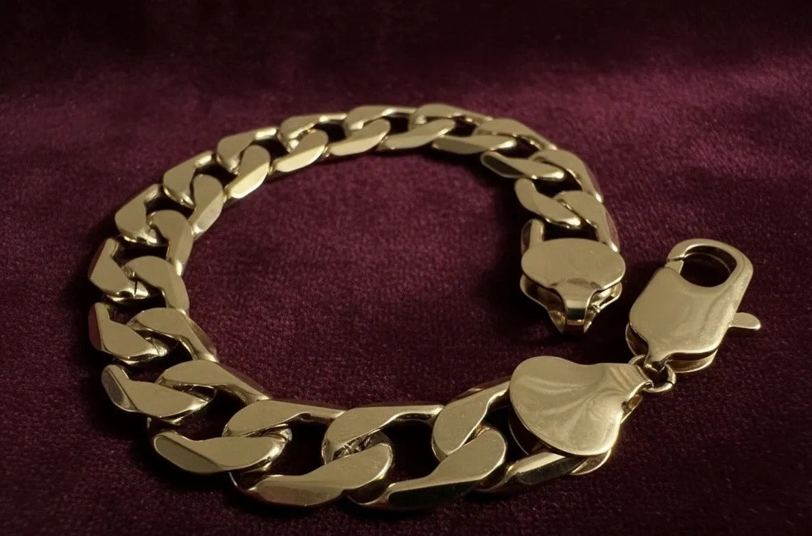 Gold chain bracelet with a clasp on a purple background