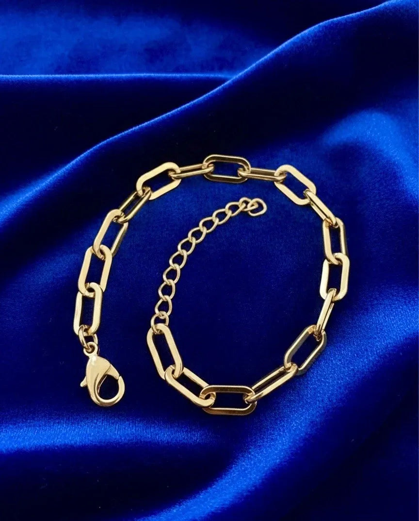 Gold chain bracelet on a blue satin background