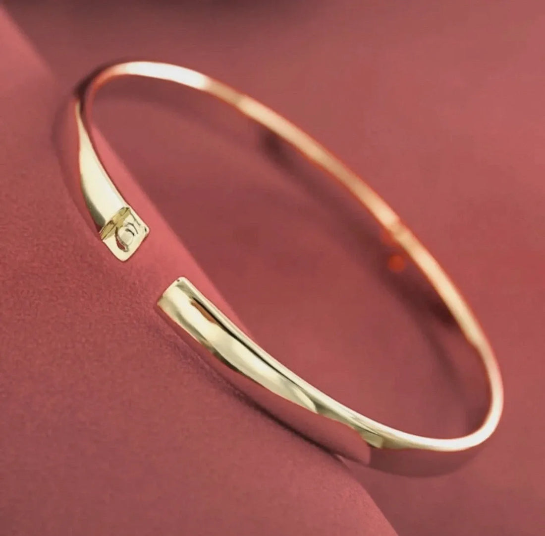 Gold bracelet on a dark fabric background